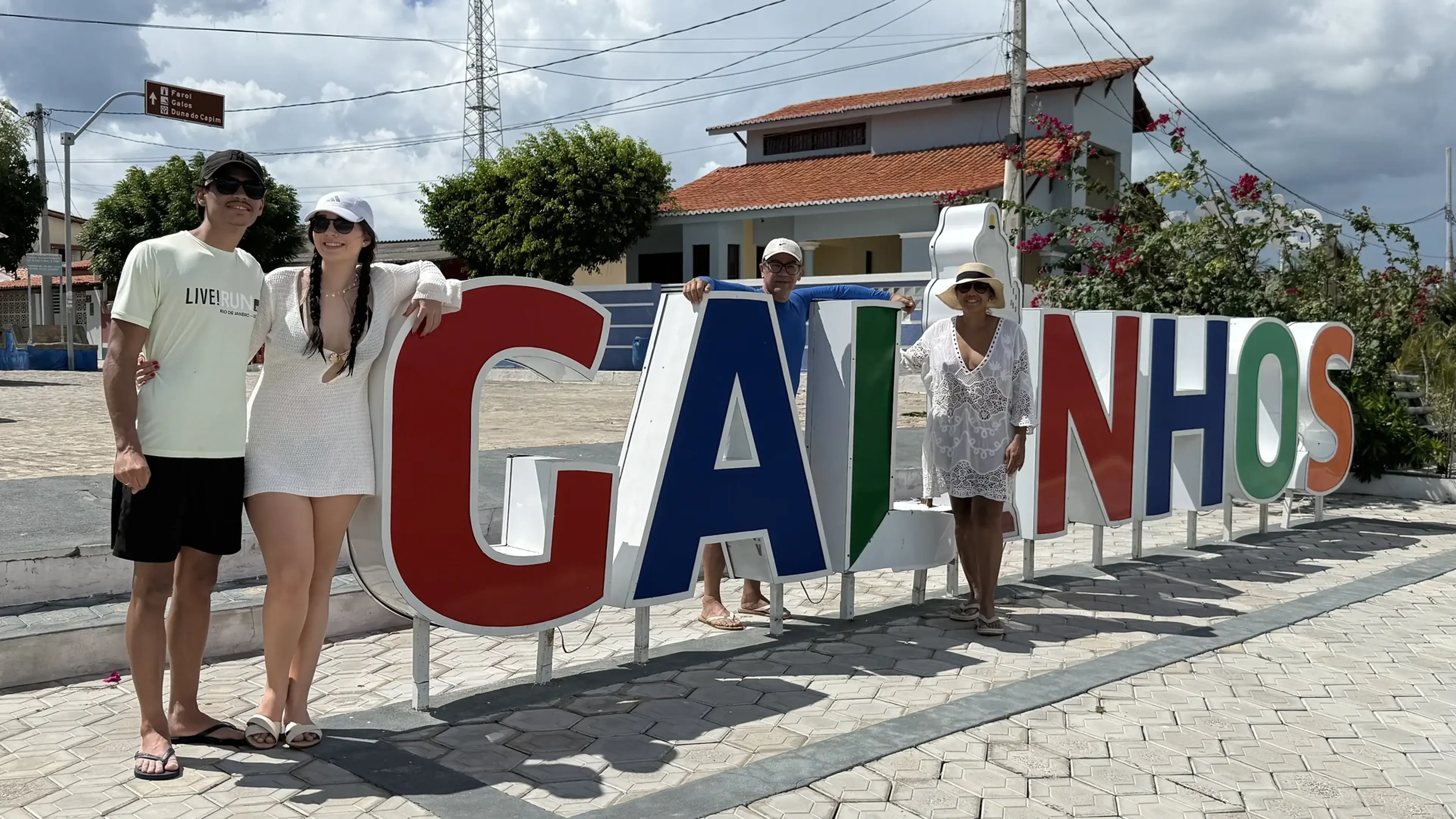 Visitantes junto ao letreiro colorido de Galinhos